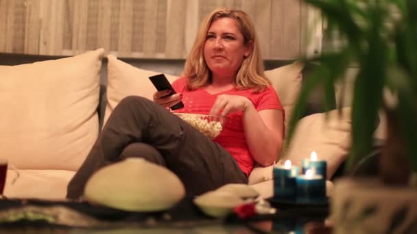 Blonde vrouw eten popcorn en kijken naar komedie film — Stockvideo