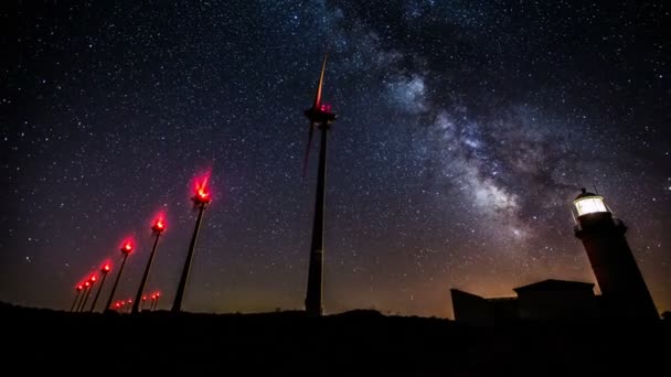 Turbine eoliche che generano energia pulita con faro sulla via lattea — Video Stock