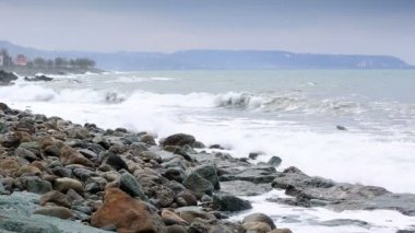 storm waves crash against the rocks