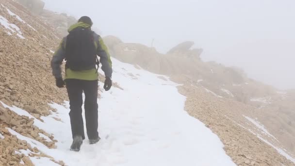 Arrampicatore che cammina sulla montagna innevata — Video Stock