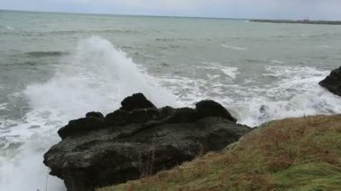 storm waves crash against the rocks