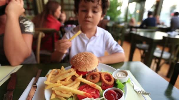 Lezzetli hamburger yiyen çocuk — Stok video