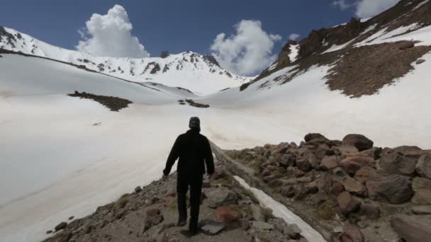 雪の山の上を歩く登山者 — ストック動画