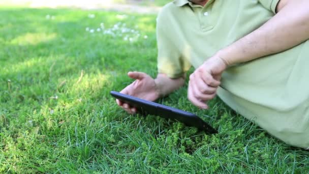 Homem usando computador tablet no parque 1 — Vídeo de Stock