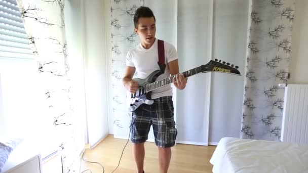 Kleiner attraktiver Junge spielt Gitarre — Stockvideo