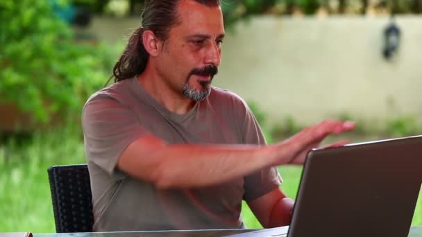 Man werkende laptop met rugklachten — Stockvideo