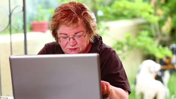 Dizüstü bilgisayar kullanan yaşlı kadın. — Stok video