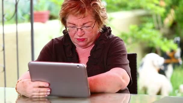 Seniorenvrouw met digitale tablet — Stockvideo