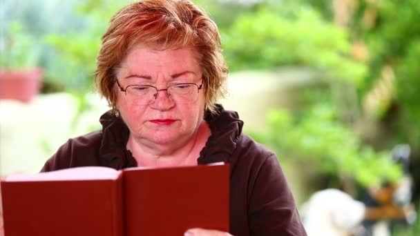 Kıdemli kadın kitap okuyor. — Stok video