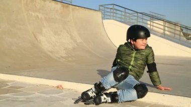 Başparmak gösterilmesini kameraya gülümseyen genç kaykaycı