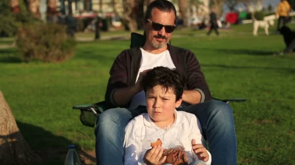 Father and son relaxing time in city park — Stock Video