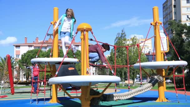 Zwei Kinder im Grundschulalter haben Spaß auf dem Spielplatz — Stockvideo