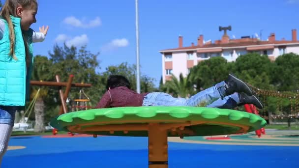 Портрет милого мальчика и девочки, играющих на детской площадке — стоковое видео
