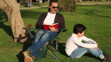 Baba oğul Park güneşli bir günde okuma