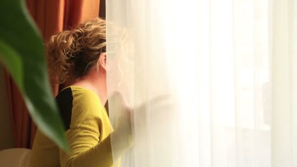 Portrait of a young woman sitting alone looking out window — Stock Video