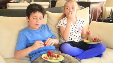 Sevimli kız ve erkek çilek yeme