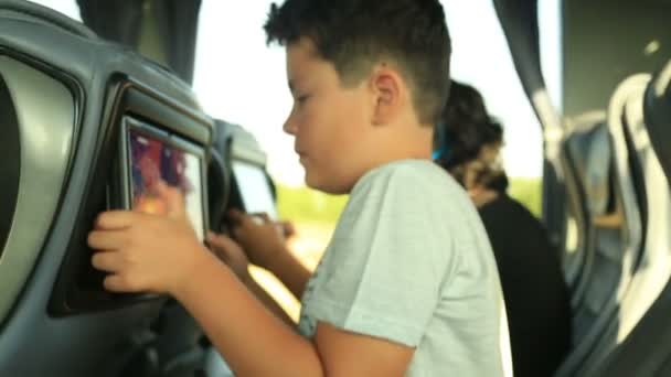 Ребенок играет в видеоигру в автобусе — стоковое видео