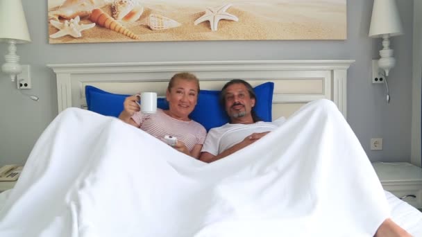 Pareja viendo la televisión en la cama juntos — Vídeo de stock