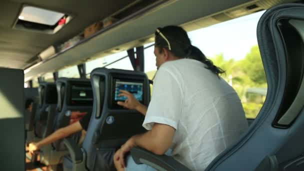 Homme regardant la télévision dans le bus — Video