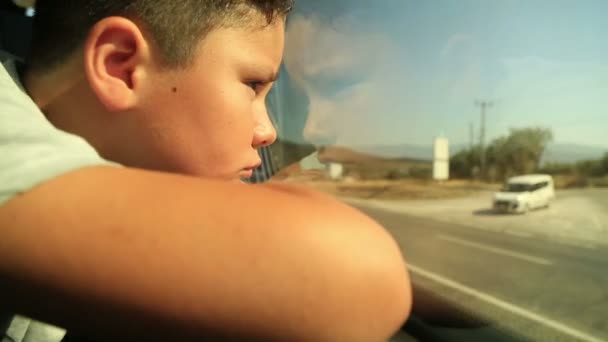 Niño triste mirando por la ventana — Vídeo de stock