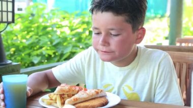 Pizza ve patates kızartması yiyen çocuk
