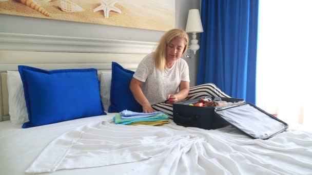 Frau packt Koffer für den Sommerurlaub — Stockvideo