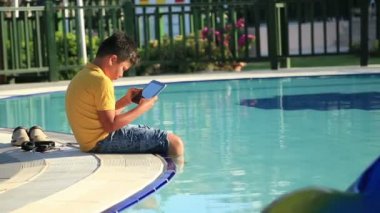 Genç çocuk havuzu dijital tablet kullanma 