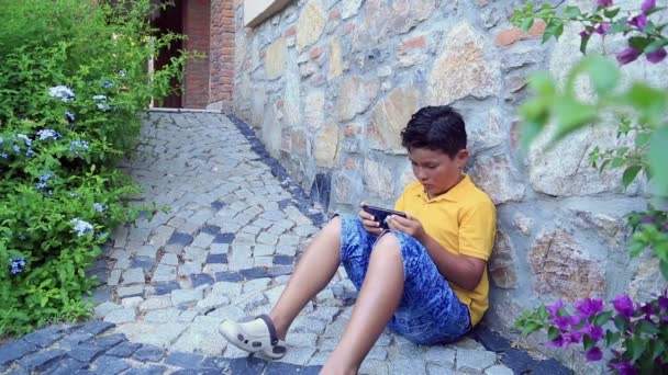 Akıllı telefon kullanan genç bir çocuk. — Stok video