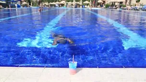 Gelukkig kind zomer drankje drinken in een pool — Stockvideo