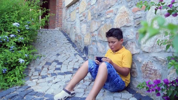 Мальчик с помощью смартфона — стоковое видео