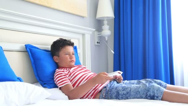 Niño con mando a distancia acostado en una cama y durmiendo — Vídeo de stock
