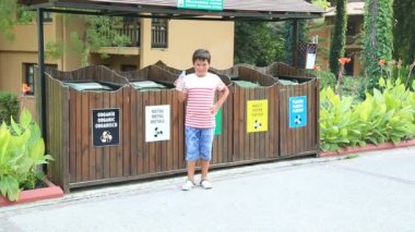 Çöp ayırma. Plastik şişe çöp kutusuna atma çocuk