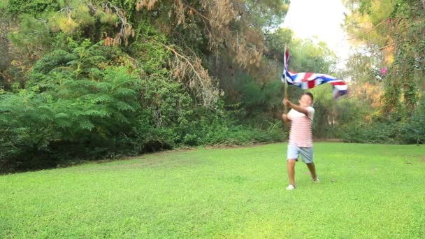 男の子笑顔と外のイギリス国旗を振って — ストック動画