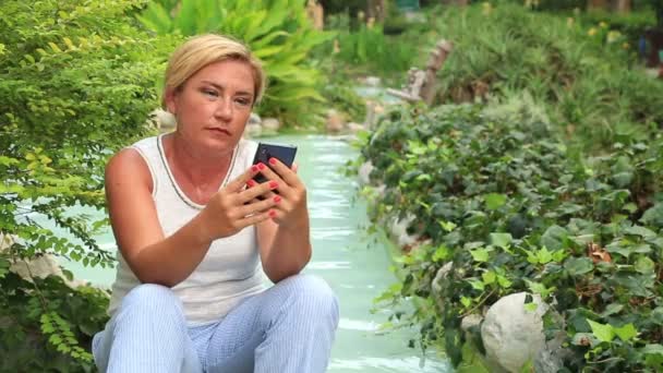 Женщина со смартфоном на открытом воздухе — стоковое видео