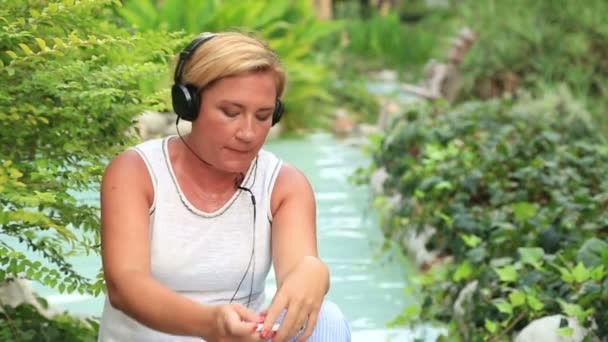 Mujer con auriculares escuchar música al aire libre — Vídeos de Stock