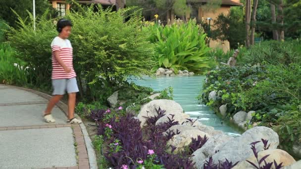 Young child with headphone relaxing at the park — Stock Video