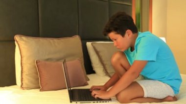 Yatağın üstünde laptop ile ödev çocuk