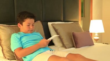 Bir yatakta yatarken ve yatak odasında çizgi film izlerken çocuk