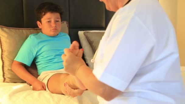 의사가 그녀의 작은 환자 발목 3 붕대를 감는 — 비디오