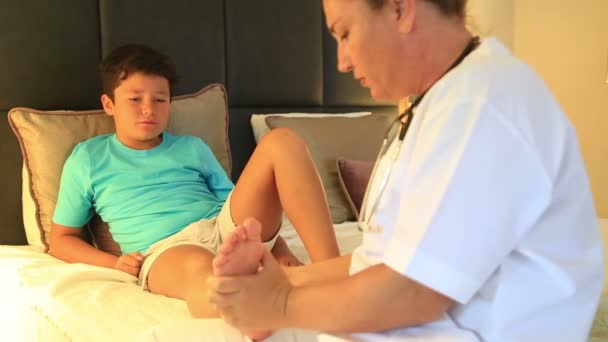 Orvos, ő kis beteg boka lekötés — Stock videók