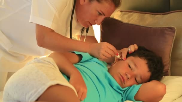 Enfermeira gotejando gotas de ouvido para criança no quarto de cama — Vídeo de Stock