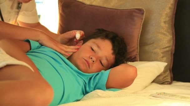 Verpleegkundige druipende eardrops kind in slaapkamer — Stockvideo