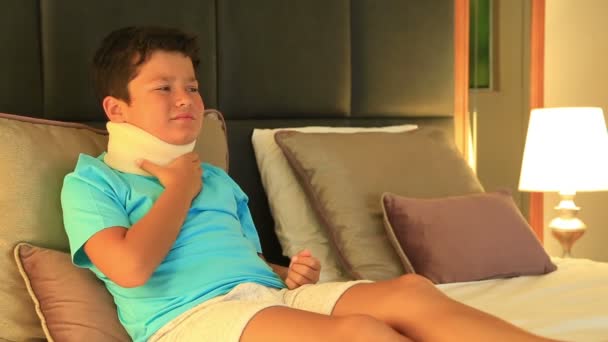 Portret van een pijnlijke kleine jongen met een nek-brace — Stockvideo
