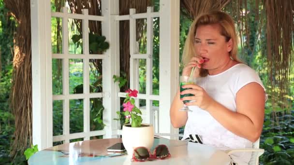 De vrouw zit op het zomerterras en drinken cocktail 4 — Stockvideo