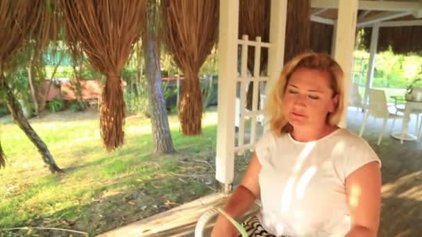 De vrouw zit op het zomerterras en cocktail drinken — Stockvideo