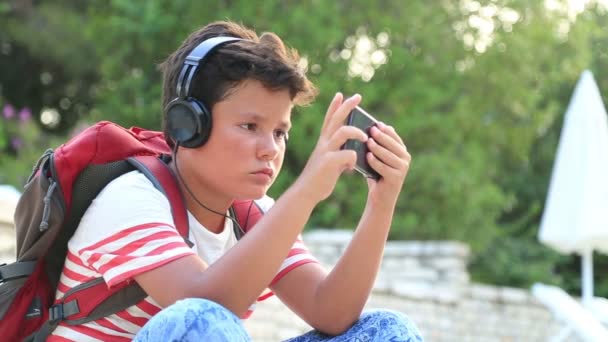 Niño escuchando música y juegos en el teléfono inteligente — Vídeo de stock