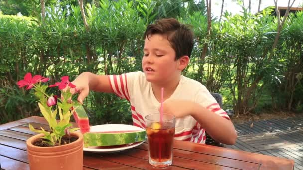 Child in a cafe, eating watermelon — Stock Video