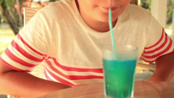 Милый счастливый ребенок пьет летний напиток в кафе — стоковое видео
