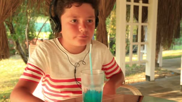 小さな男の子のカフェで音楽を聴く — ストック動画