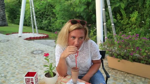 Vrouw drinken frappe in café — Stockvideo
